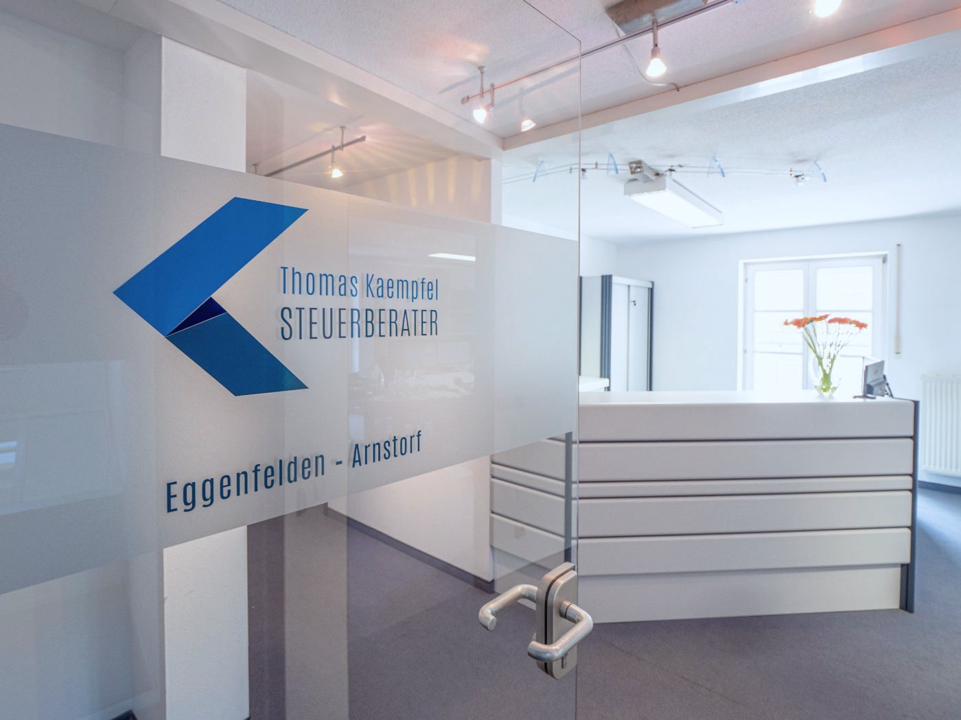 Eingang der Kanzlei mit Logo an der Glastür